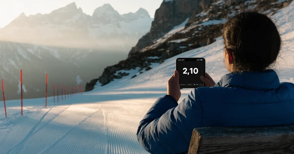 Ein frisch präparierter Hang mit Slalomstangen in einer Reihe im ersten Morgenlicht, Schneespuren im Hang und Berge im Hintergrund.